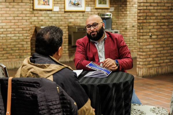 Jose Capeles (right) speaking to an attendee